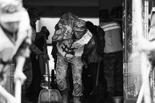 9日,武警甘肃总队机动支队官兵在榆中县城关镇兴隆山村帮助受灾群众转移物资